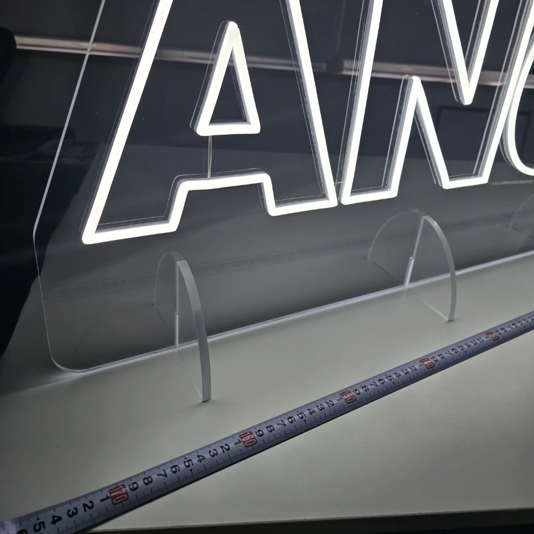 ANOBAKAロゴのLEDネオンサイン看板。アクリル立て台で立つスタンドタイプを点灯して立て台部分をクローズアップした写真。