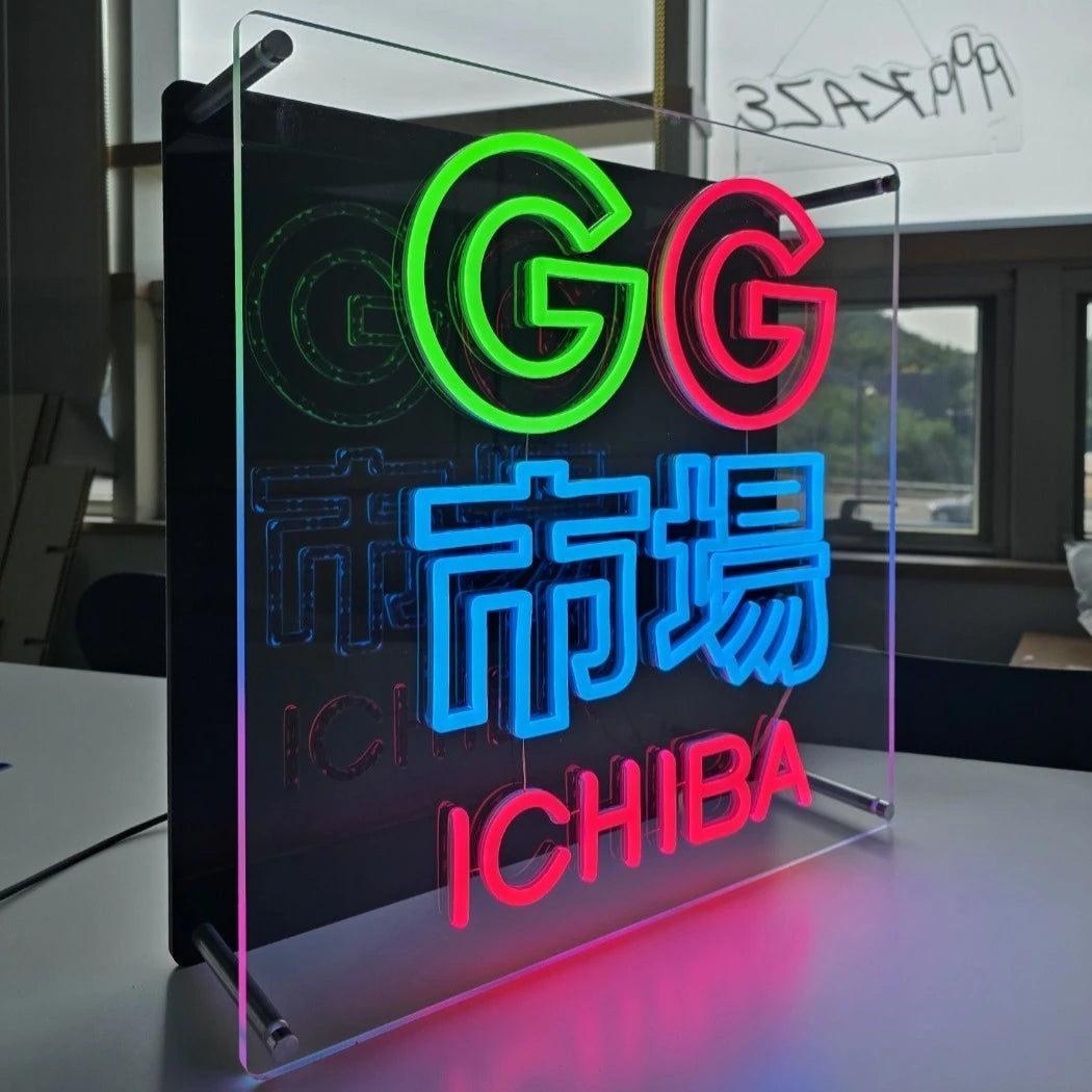 GG市場ロゴのLEDネオンサイン看板。金属スペーサーと２枚のアクリル板で立つスタンドタイプを点灯時に左側から撮影したアングル。