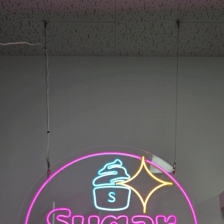 SugerSugerロゴのLEDネオンサイン看板。天井吊り下げタイプの吊り下げフック部分と本体上部の写真。