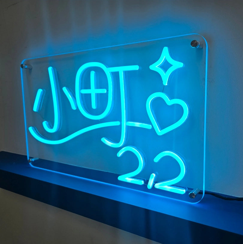 オリジナルロゴをブルーLEDで表現した壁面固定タイプのネオンサイン製作事例。透明アクリルベースと壁面の間にスペーサーを介してビスで固定する仕様。