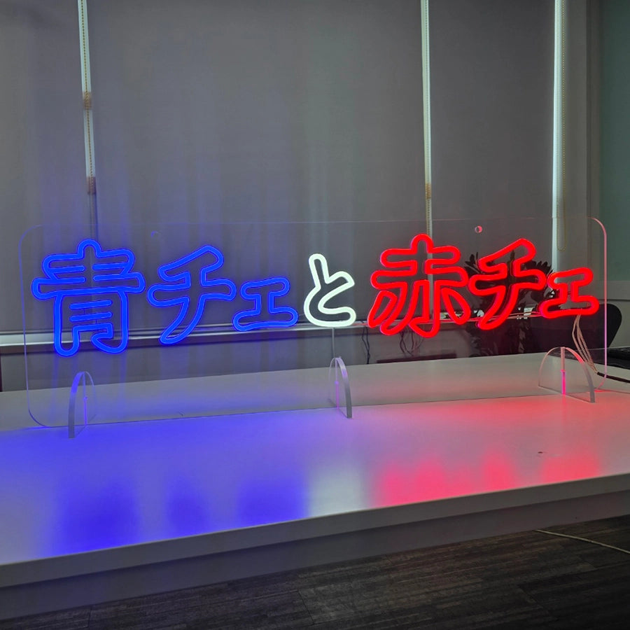青色と白色と赤色のLEDネオンサイン製作事例。アクリル立て台のスタンドタイプで、天井吊下げも可能な穴加工を上部に施した製品。「青チェと赤チェ」の文字を発光で表現したアクリルベースのオーダーメイドネオン看板。