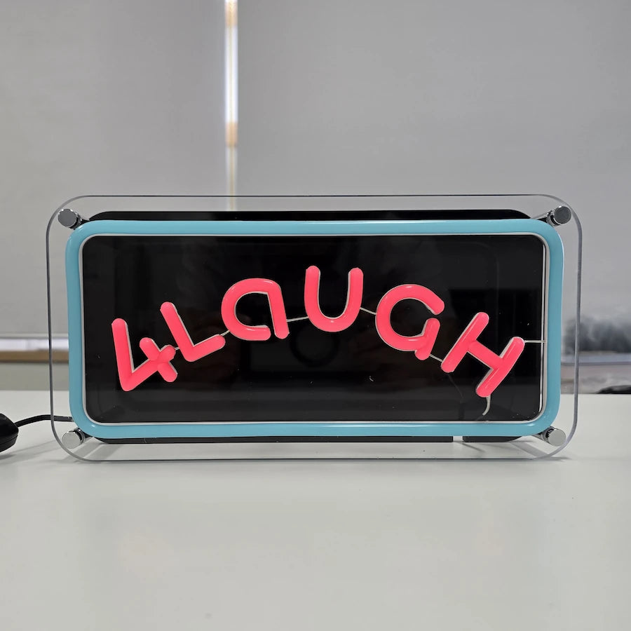 ４LaUGHロゴのLEDネオンサイン看板。金属スペーサーと２枚のアクリル板で立つスタンドタイプを消灯時に正面から撮影した写真。