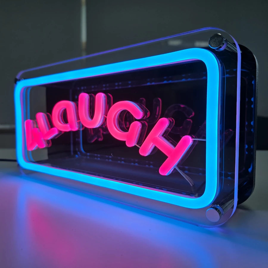 ４LaUGHロゴのLEDネオンサイン看板。金属スペーサーと２枚のアクリル板で立つスタンドタイプを点灯時に右斜めから撮影したアングル。