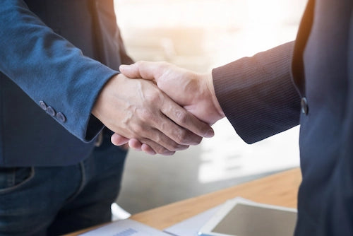 スーツを着た男性同士が向かい合っている握手をしている様子,企業専用