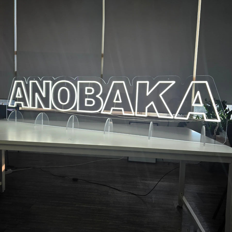 ANOBAKAロゴのLEDネオンサイン看板。アクリル立て台で立つスタンドタイプを点灯して正面から撮影したアングル。