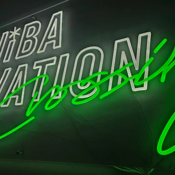 CHiBA INNOVATIONロゴのLEDネオンサイン看板。壁面タイプを点灯した状態で、製品をクローズアップした写真。