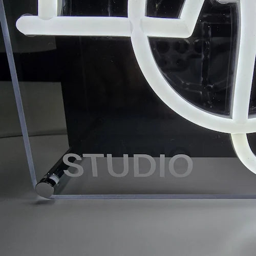 EOU STUDIOロゴのLEDネオンサイン看板。金属スペーサー仕様のスタンド2タイプをクローズアップして”STUDIO”ロゴ部分を撮影した写真。