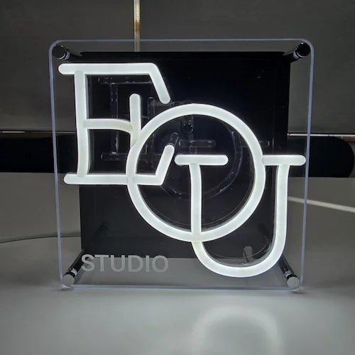 EOU STUDIOロゴのLEDネオンサイン看板。金属スペーサー仕様のスタンド2タイプを薄暗い場所で点灯し、正面から撮影した全体写真。