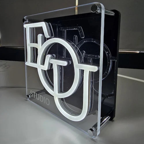 EOU STUDIOロゴのLEDネオンサイン看板。金属スペーサー仕様のスタンド2タイプを点灯し、右側から撮影した写真。