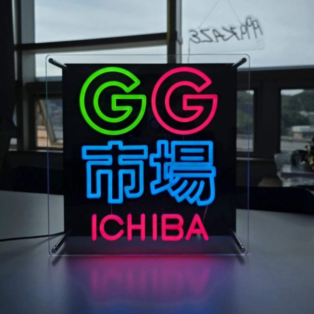 GG市場ロゴのLEDネオンサイン看板。金属スペーサーと２枚のアクリル板で立つスタンドタイプを点灯時に正面から撮影したアングル。