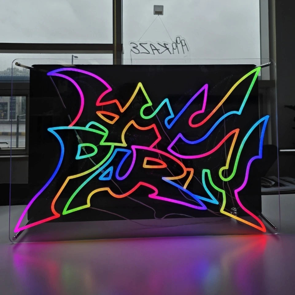 KMNPARTYロゴのLEDネオンサイン看板。金属スペーサーと２枚のアクリル板で立つスタンドタイプを点灯時に正面から撮影した写真。