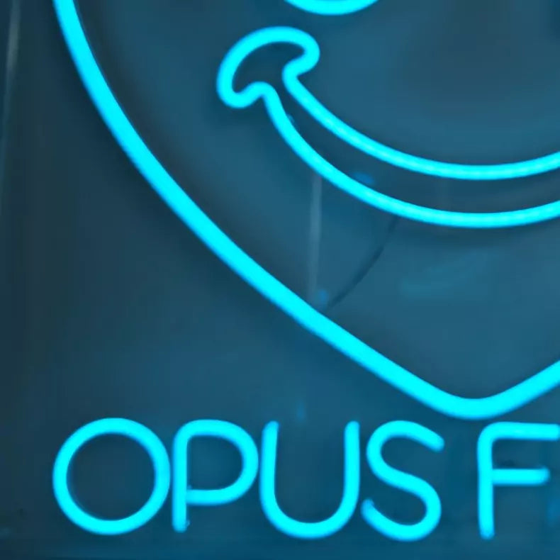 OPUSFILMロゴのLEDネオンサイン看板 壁面設置タイプのクローズアップ写真